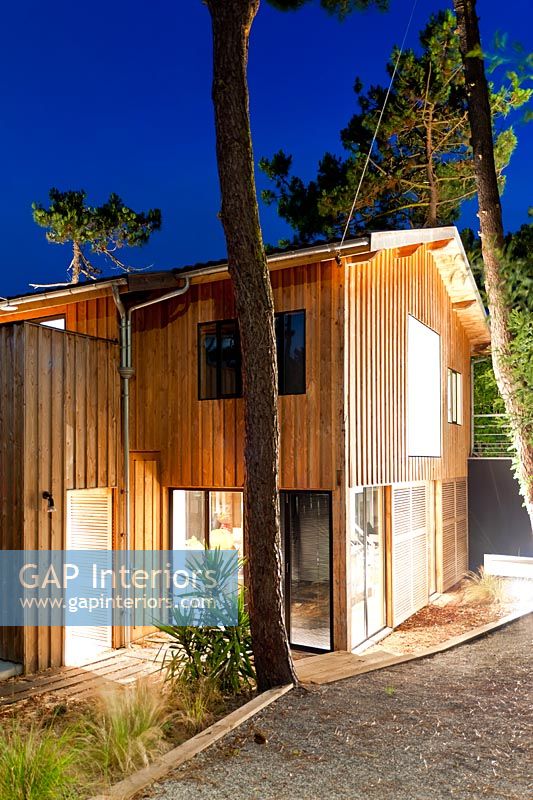 Contemporary wooden house lit up at night