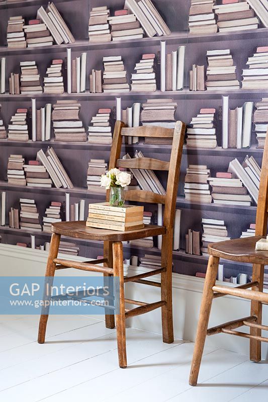 Wooden chairs and patterned wallpaper