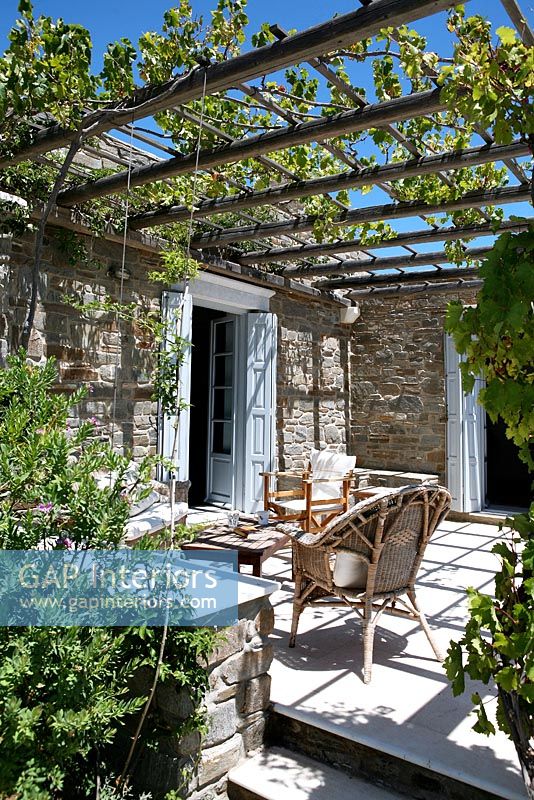 Traditional stone house and patio under pergola