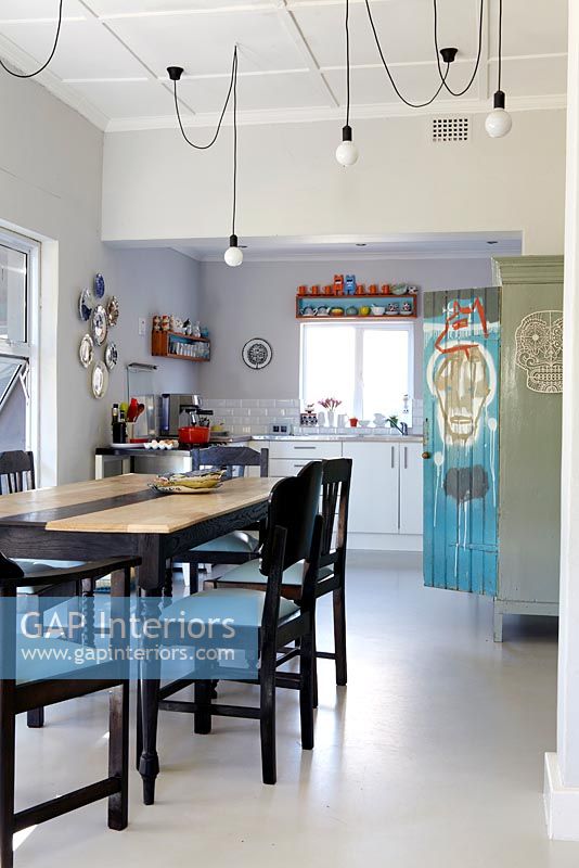 Modern kitchen diner with artwork on cupboard by Conrad Botes
