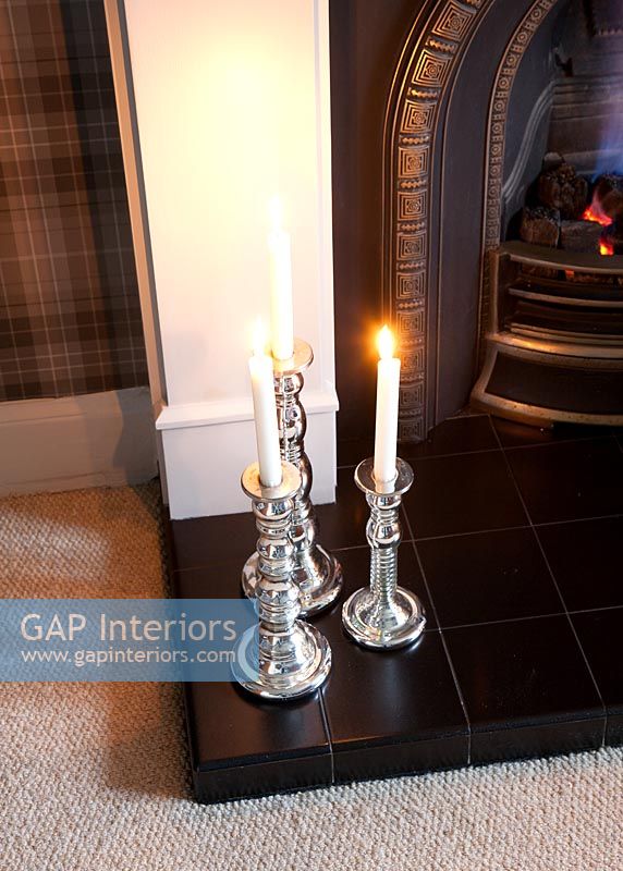 Silver candlesticks on hearth