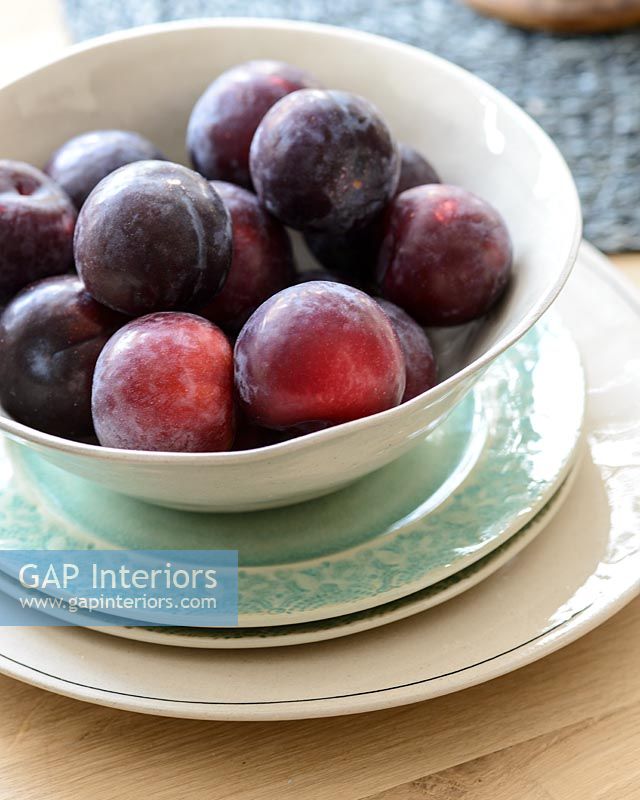 Plums in white bowl