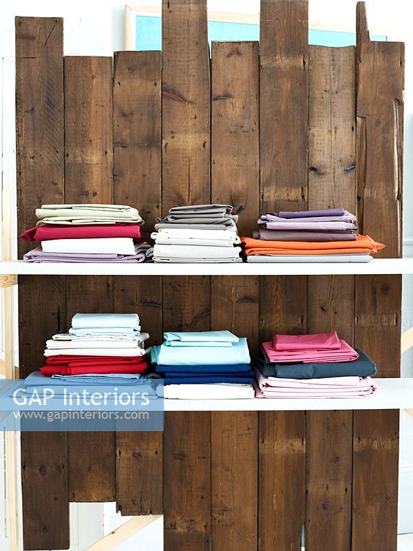 Colourful fabrics on wooden shelves