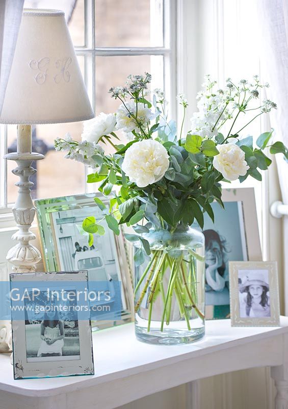 Low table with display of photos and Roses in vase