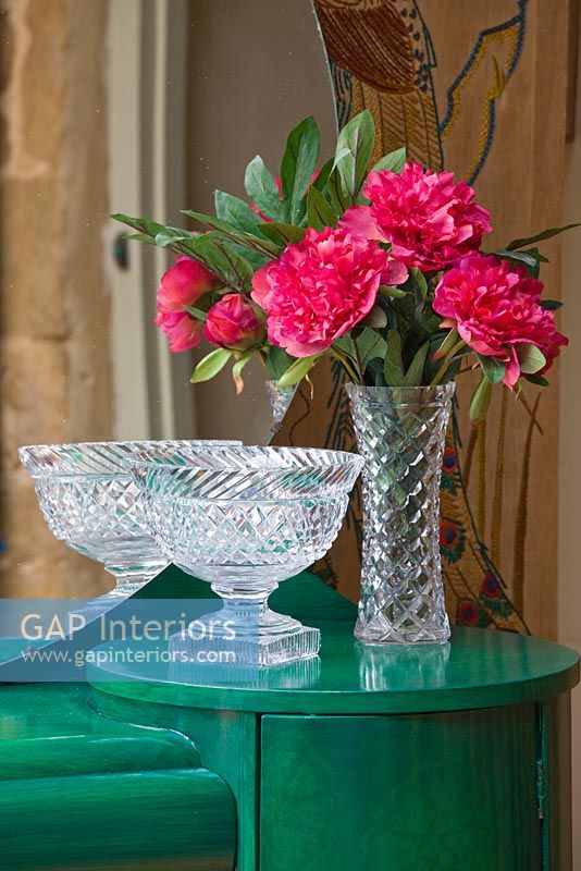 Red Peony flowers in antique crystal vase