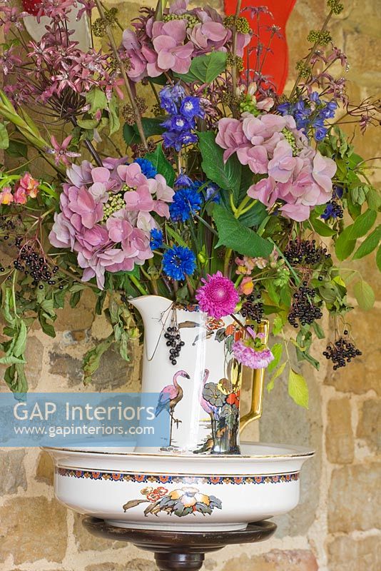 Colourful flowers including Hydrangea and Cornflowers in patterned jug