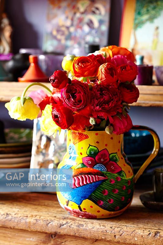 Ranunculus flowers in patterned jug