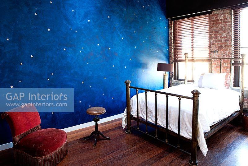 Bedroom with vintage furniture and night sky mural