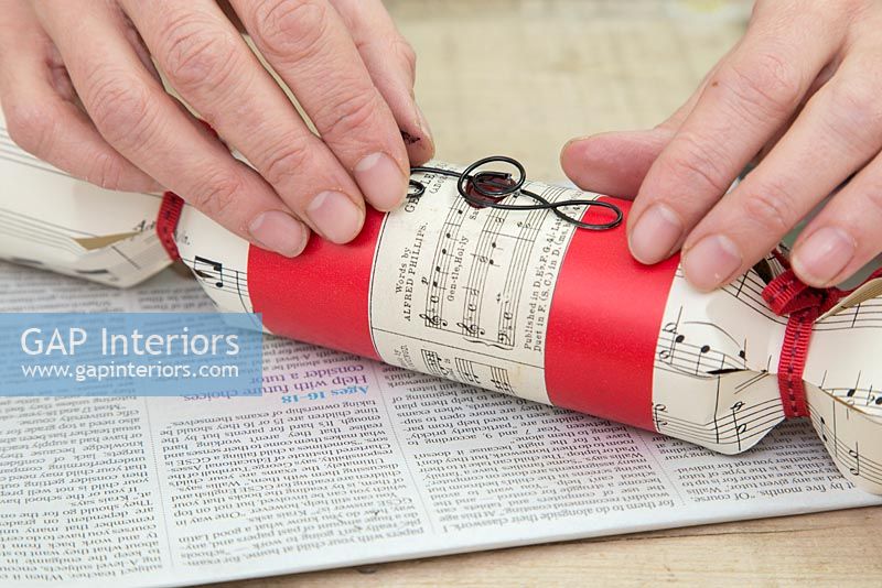 Step by Step guide for making Christmas Crackers from scratch - attaching music note on to wax