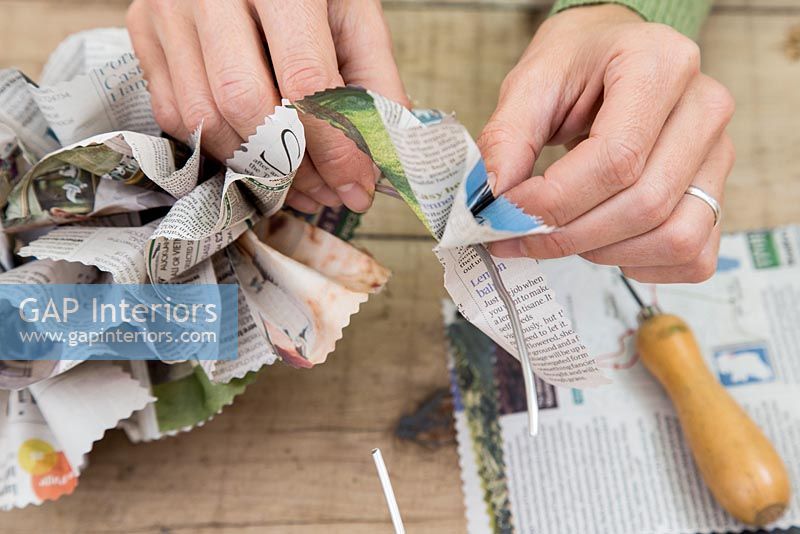 Creating a simple Christmas wreath using newspaper and  wire - adding section to wreath