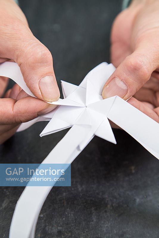 Using paper strips to create star shaped decorations - repeating folding technique to create multiple spiky sections