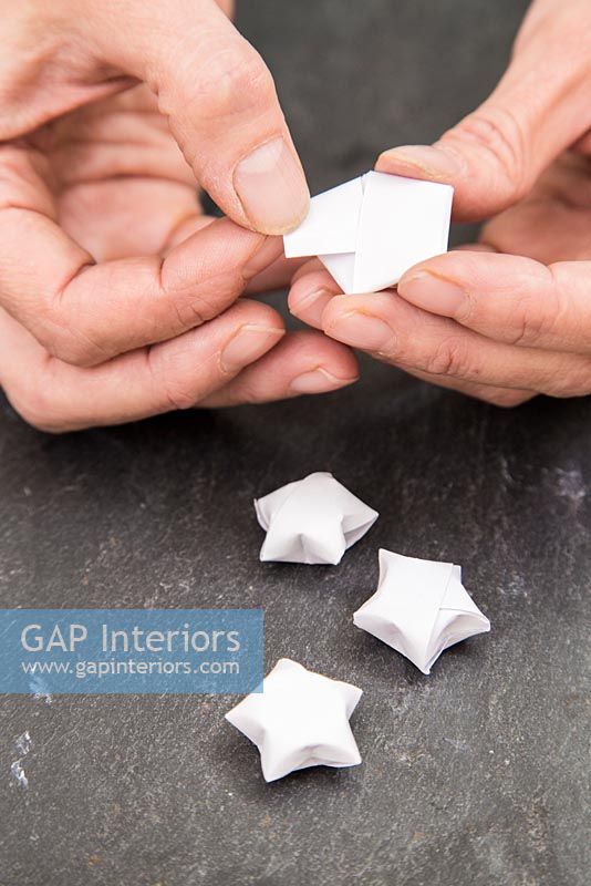 Using paper strips to create star shaped decorations - tucking away final section within shape