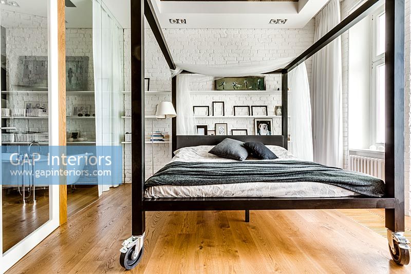 Modern four poster bed on casters