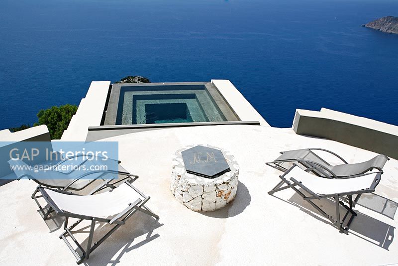Modern patio and pool overlooking sea