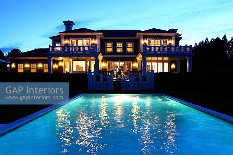 Classic house and swimming pool lit up at night