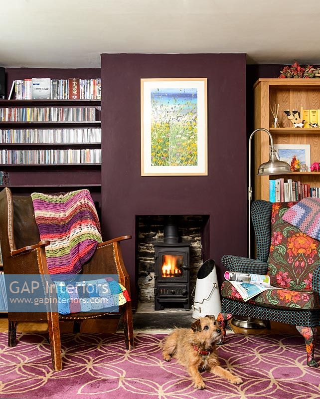 Colourful armchairs by fireplace