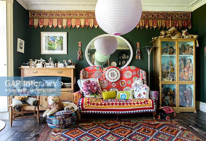 Colourful sofa surrounded by collectibles