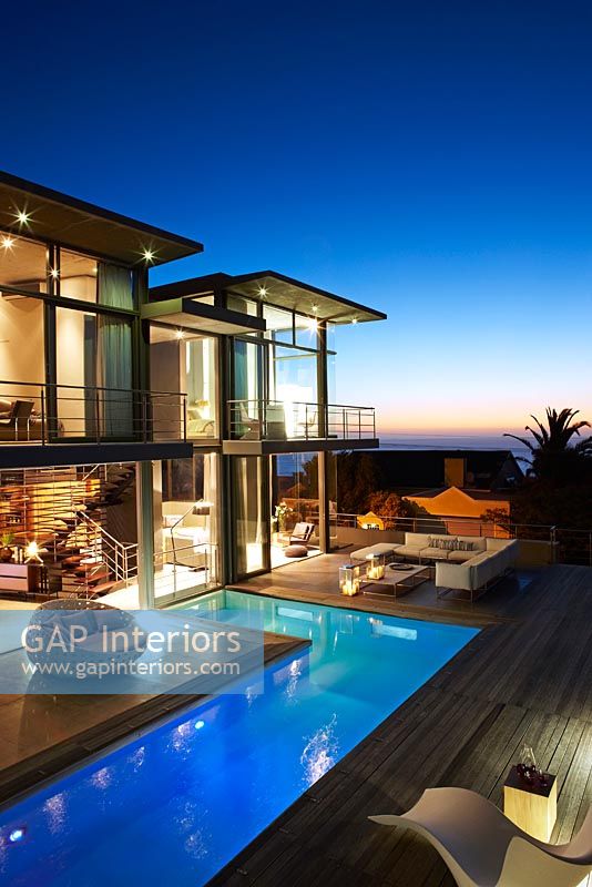 Contemporary house and pool lit up at night