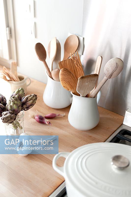 Wooden spoons in white jugs