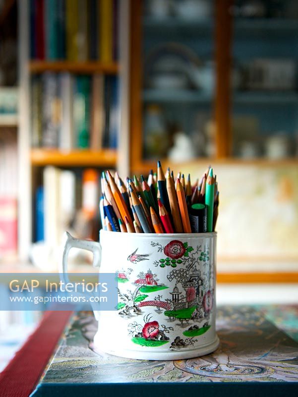 Coloured pencils in patterned mug