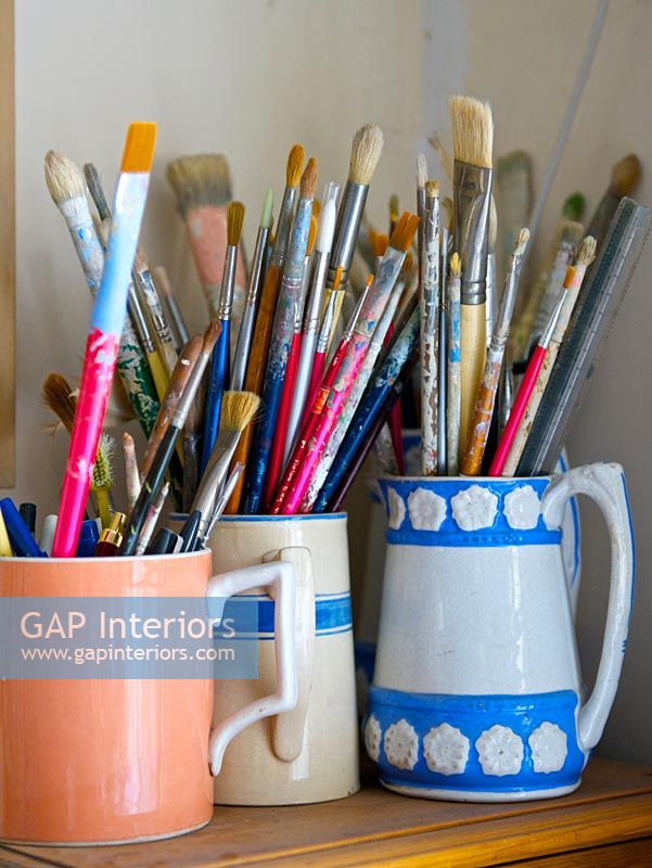Paint brushes in patterned mugs