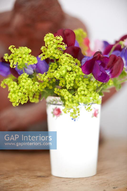 Posy of Ladys mantle and Sweet pea flowers in white beaker