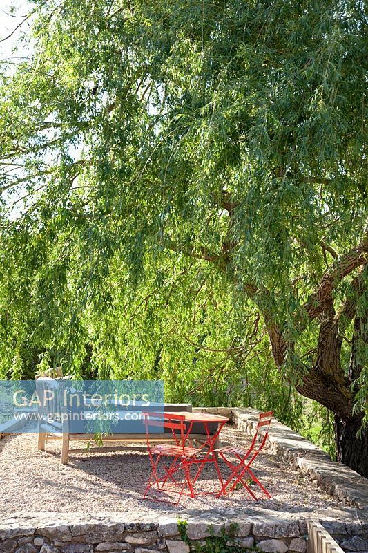 Gravel patio in the shade of Willow tree