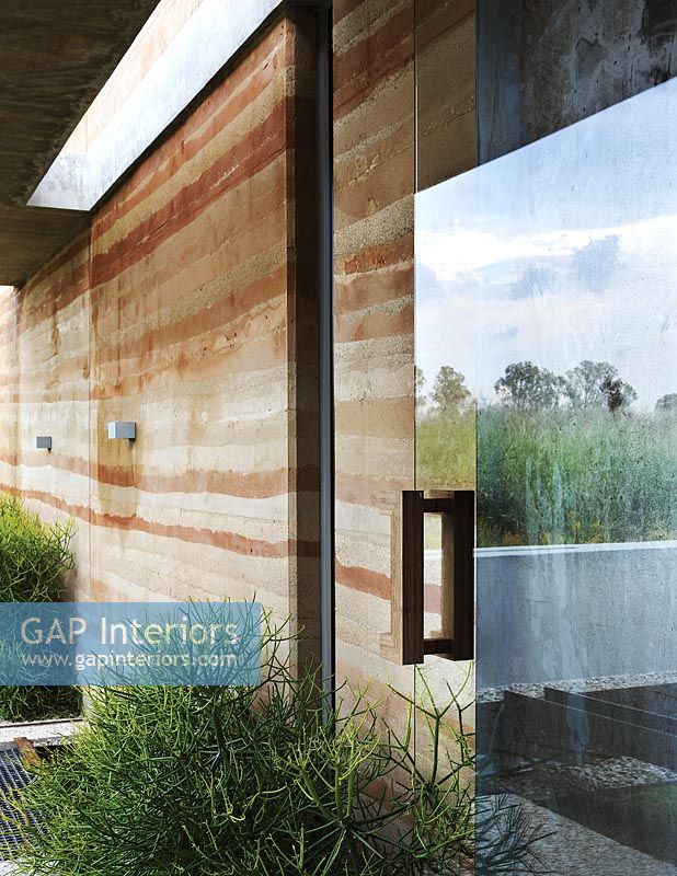 Contemporary house with rammed-earth wall