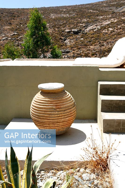 Clay urn and concrete wall
