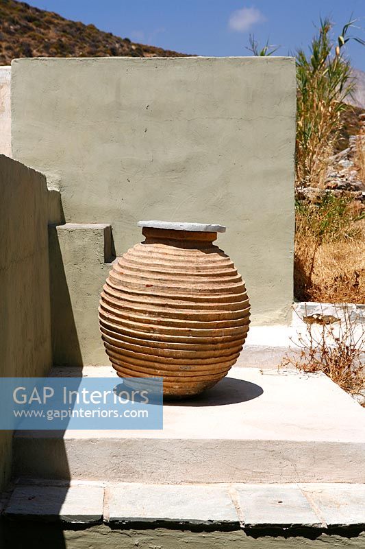 Clay urn and concrete wall