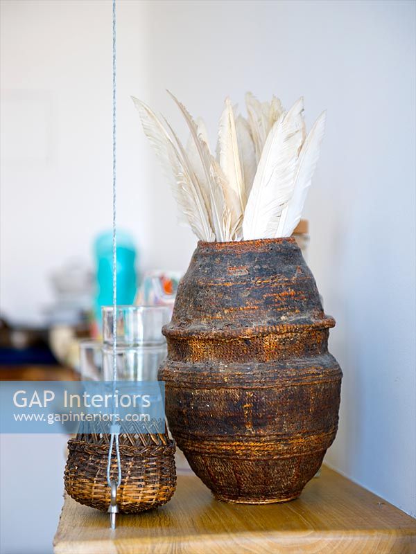 White feathers in rustic vase