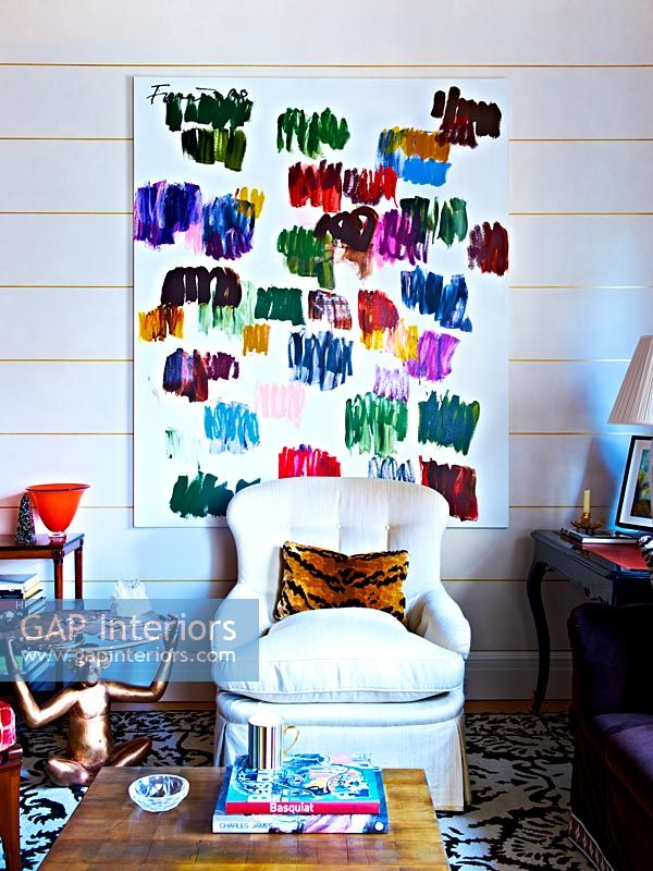 Abstract painting hung above classic armchair