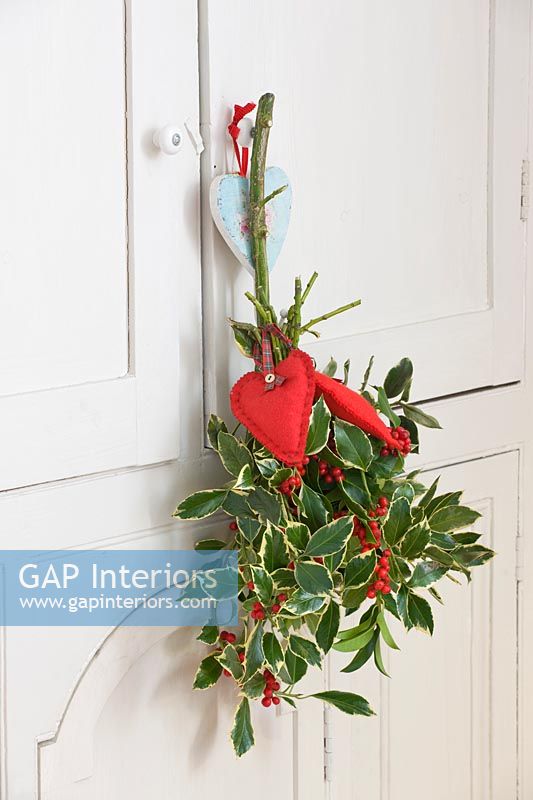 Sprigs of Holly with felt hearts hanging in kitchen
