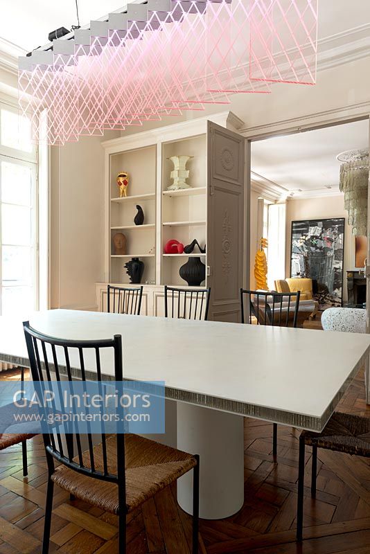 Modern dining room with designer furniture and pink suspended light by Johanna Grawunder