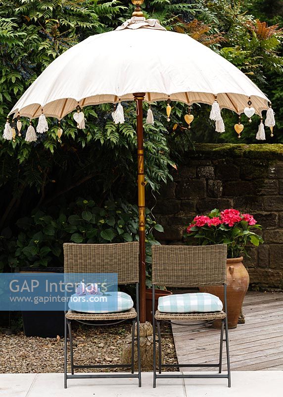 Wicker garden chairs under parasol
