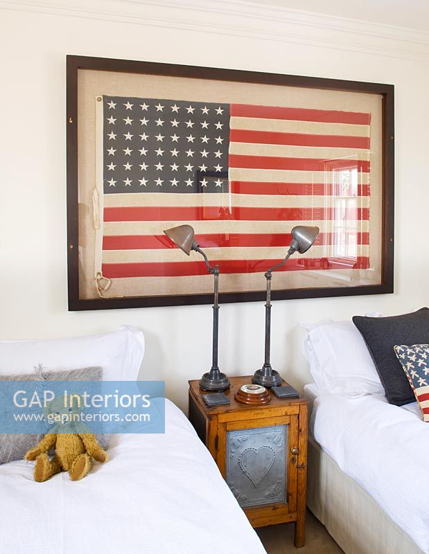 Vintage framed US flag above punched zinc fronted bedside cabinet
