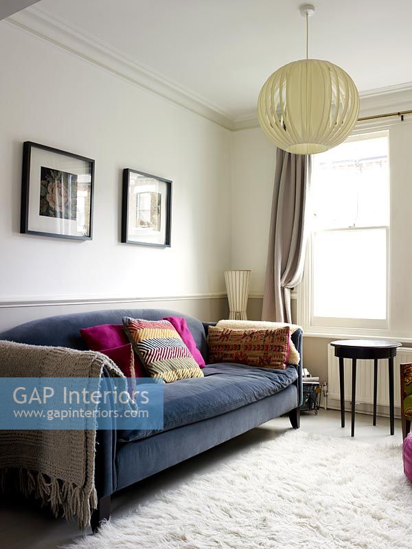 Colourful throws and cushions on grey sofa