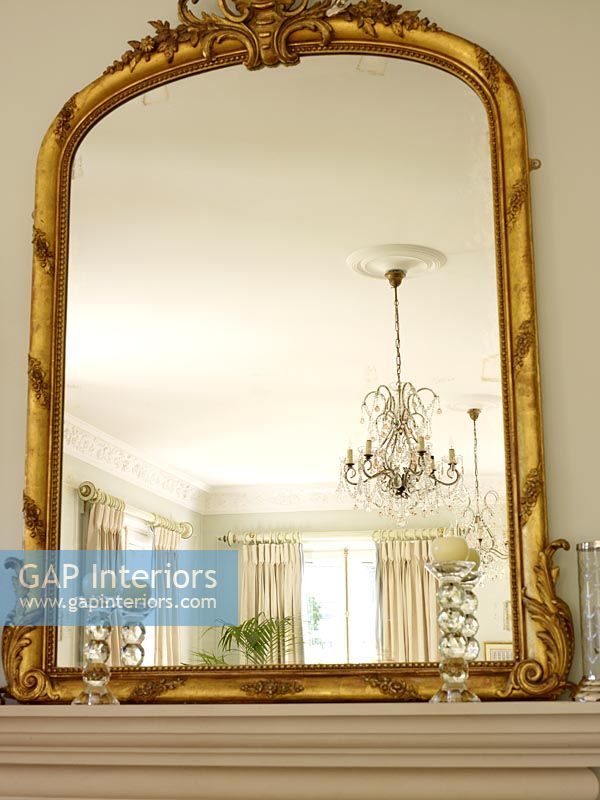 Gold framed mirror on mantlepiece
