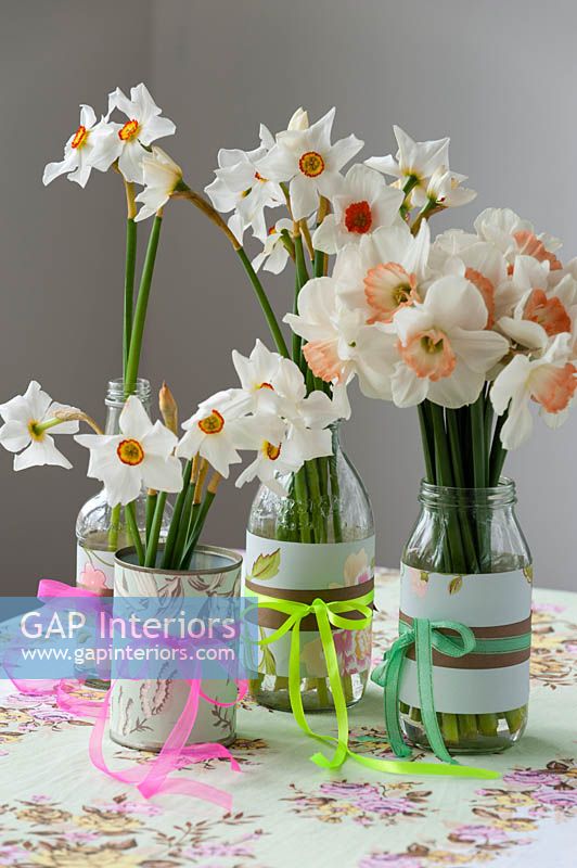 Daffodil flowers arranged in bottles and cans