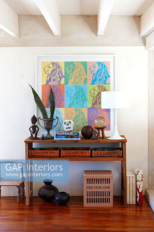 Eclectic art and ornaments on wooden console table