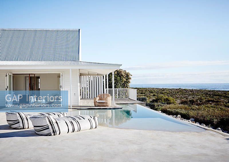 Modern house and pool overlooking sea