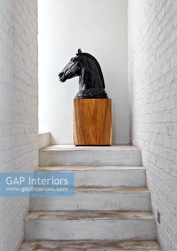 Horse sculpture on wooden plinth