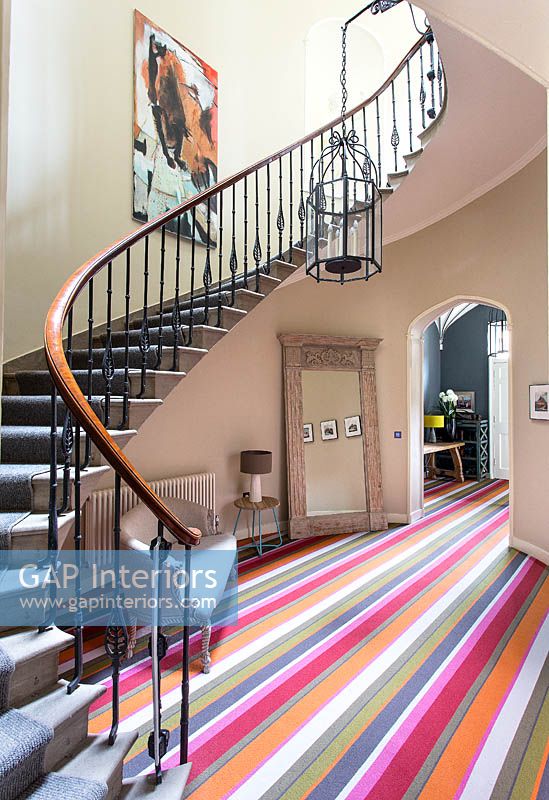 Colourful hallway with curved staircase