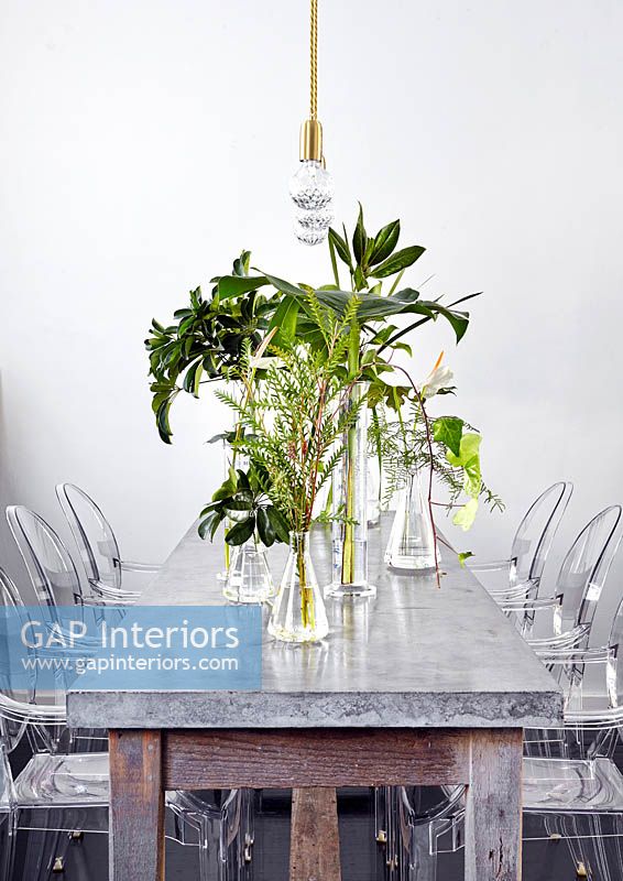 Vases of tropical foliage on dining table