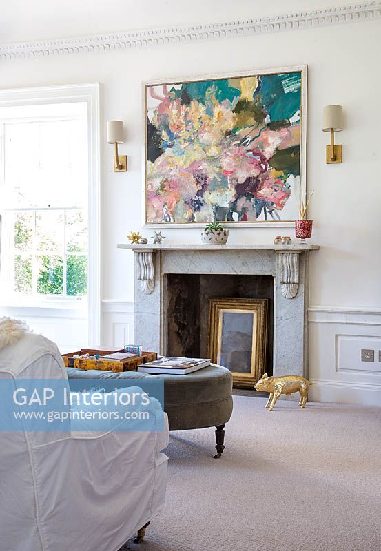 Modern painting above marble fireplace