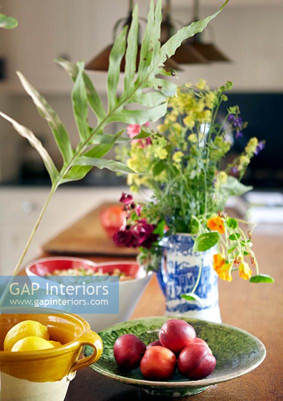 Colourful fruit and flowers on kitchen counter