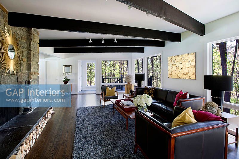 Modern living room with a stone wall and exposed beams 