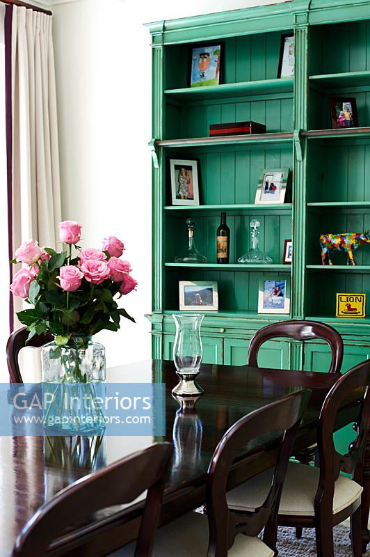 Green bookshelves in dining room