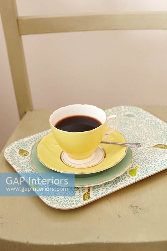 Vintage tea cup on patterned tray