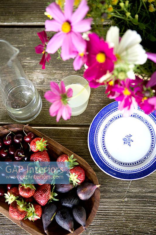 Fresh fruits and flowers on garden table